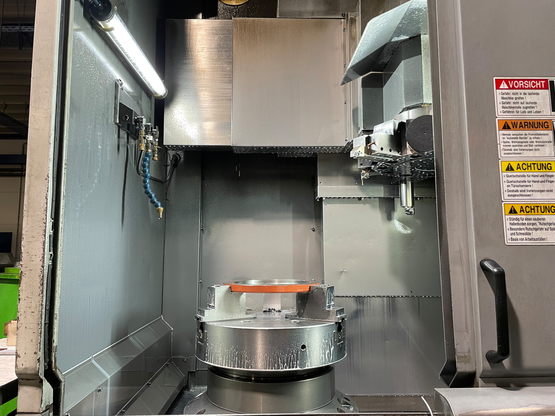 Blick in den Arbeitsraum einer computergesteuerten CNC-Drehmaschine während des Bearbeitungsprozesses